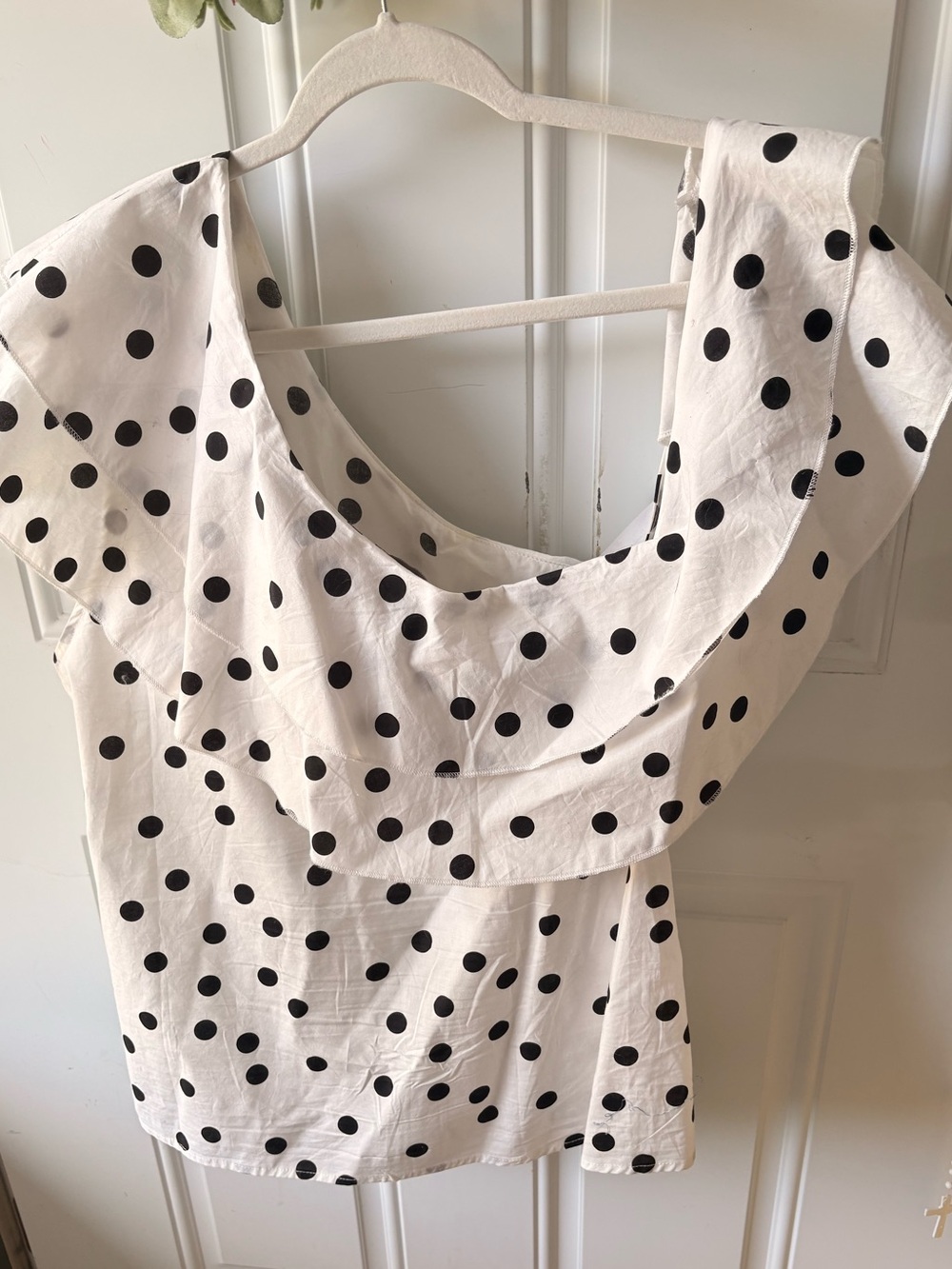 Classic and feminine black-and-white polka-dot blouse featuring multiple layered